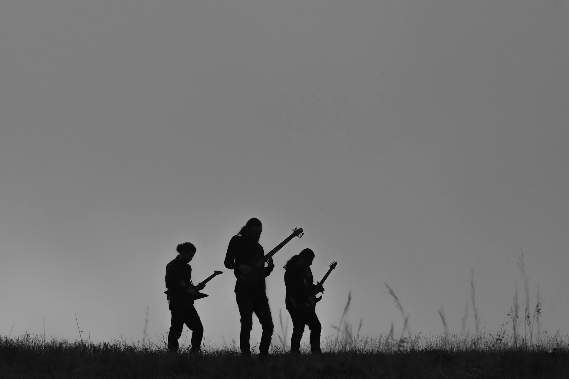 Czarno-biała sylwetka rockowego zespołu grającego na otwartym plenerze