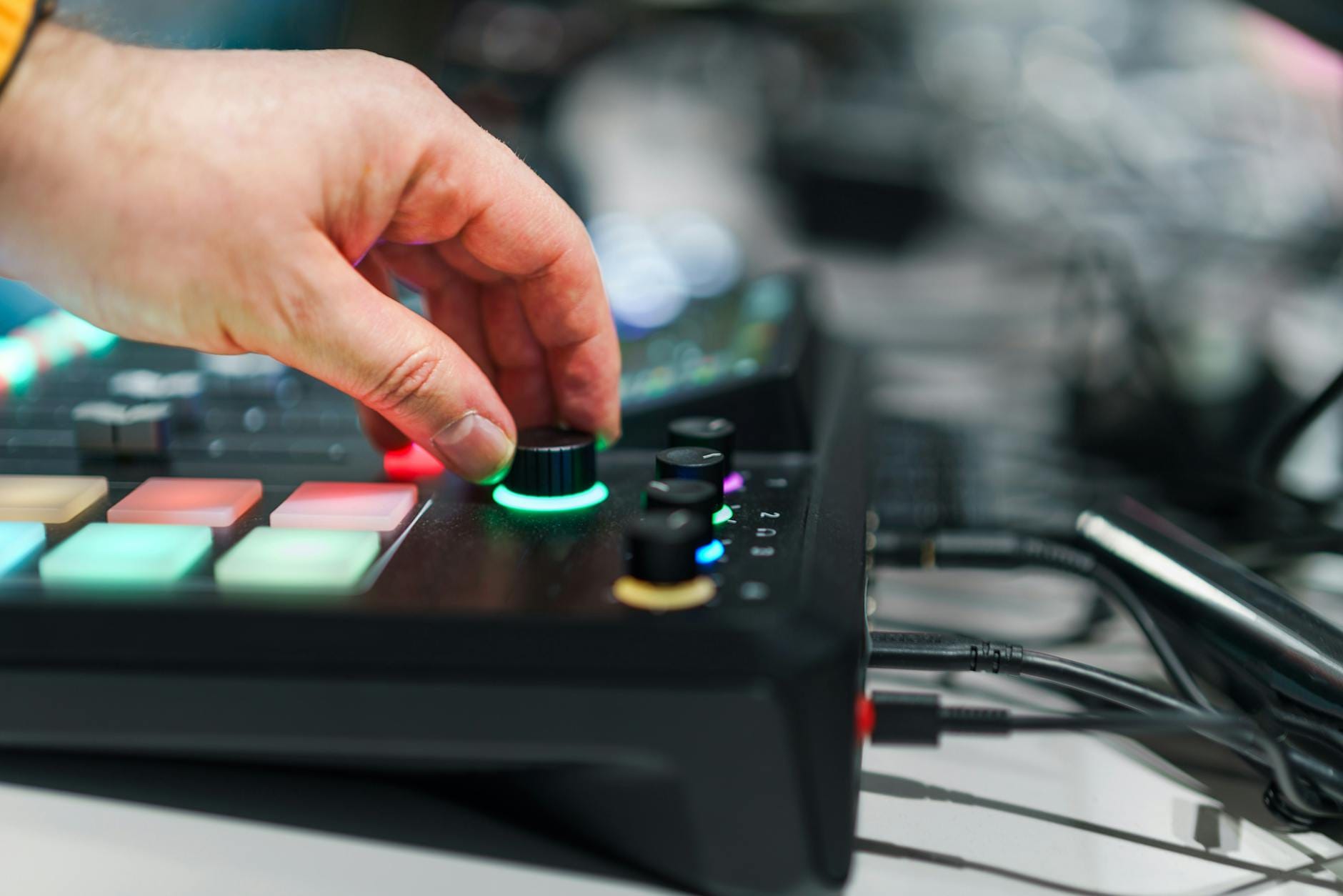 Dłoń regulująca pokrętła miksera dźwięku w nowoczesnym studiu