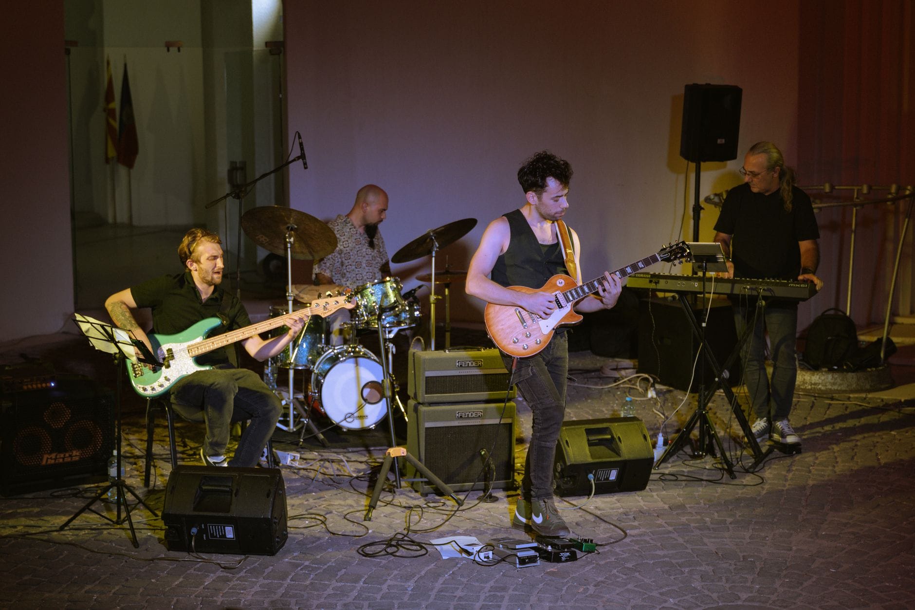 Rockowy zespół z gitarą, basem i perkusją grający na scenie