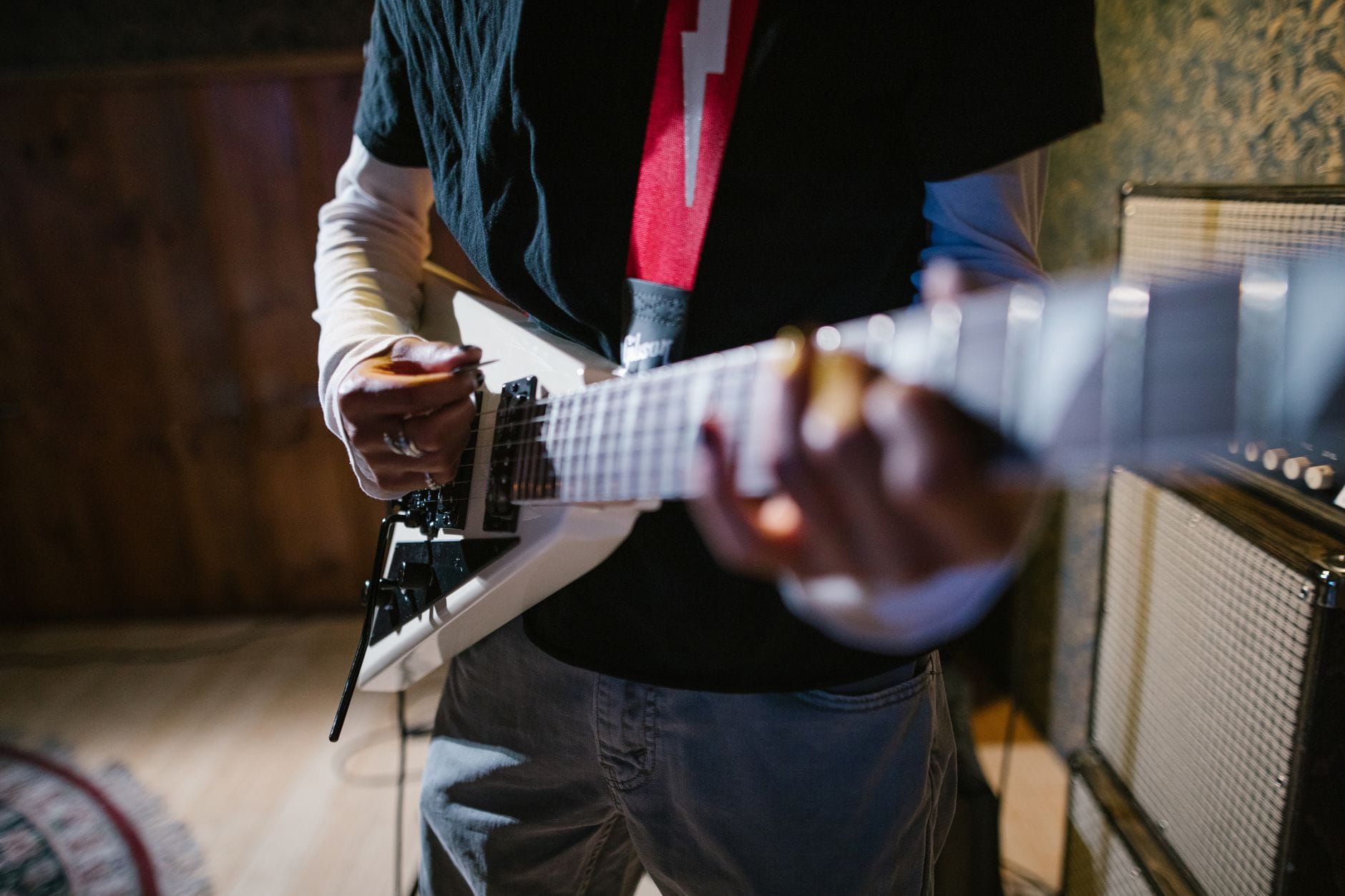Zbliżenie na dłonie gitarzysty grającego na elektrycznej gitarze Zbliżenie na dłonie gitarzysty grającego na elektrycznej gitarze