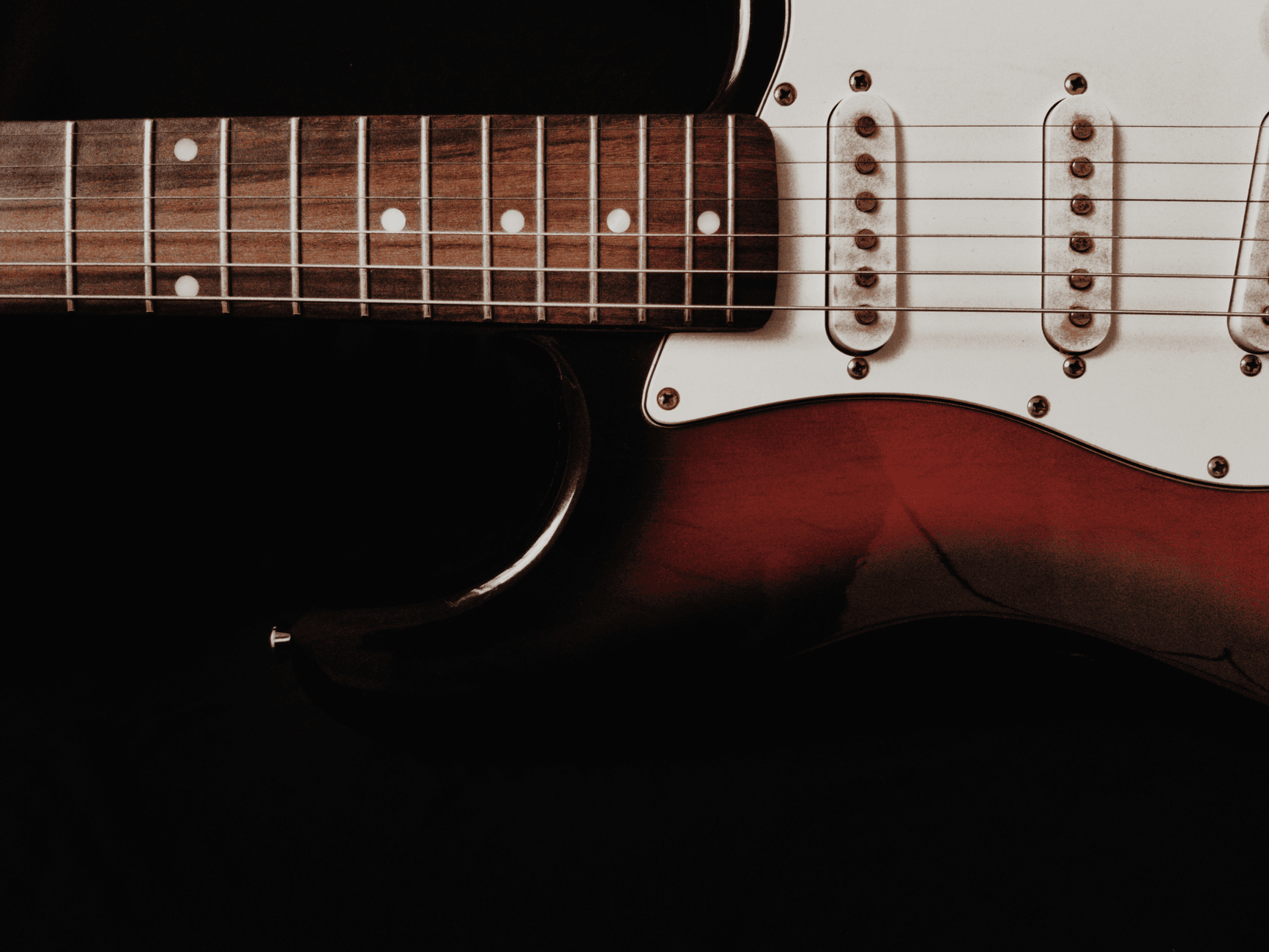 Zbliżenie na elektryczną gitarę na ciemnym tle w stylu rocka progresywnego Zbliżenie na elektryczną gitarę na ciemnym tle w stylu rocka progresywnego