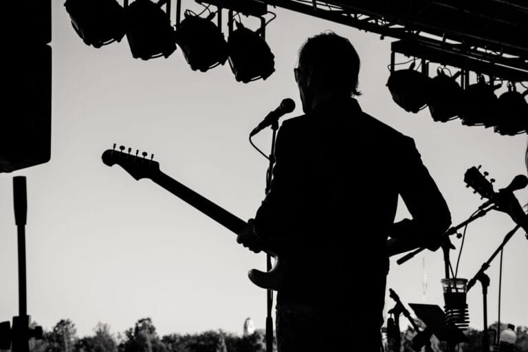 Sylwetka gitarzysty podczas plenerowego koncertu art rockowego